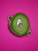 Green roasting pan on pink background