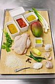 Chicken with other ingredients for curry on wooden board