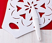Cake server, decorative stencil and cake solver on wooden surface