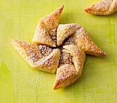 Turbine shaped puff pastry with icing sugar on green background