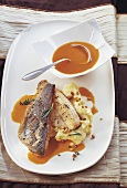 Crispy fried fish with bourride sauce on oval plate