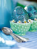 Gartenküche, Bemaltes Ei im Eierbecher, Gänseblümchen