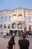 Tourists standing near Pula Arena amphitheater in Croatia