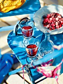 Garden kitchen table with glasses and frozen berries on blue chair, garden kitchen