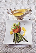 Green asparagus with peperonata polenta on plate and curry hollandaise in sauce boat