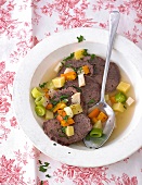 Boiled beef broth with vegetables in bowl