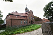 Facade of Kletkamp gatehouse with garden in front in Schleswig-Holstein, Germany