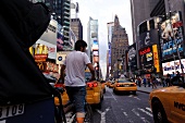 Woman getting in taxi at Times Square in New York, USA