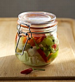 Chopped oriental vegetables in glass jar