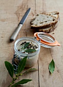 Homemade pork rillettes with laurel leaves in air tight jar