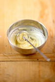 Blended egg yolk and lemon juice with whisk in bowl while preparing mayonnaise, step 1