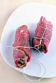 Bound meat stuffed with vegetables on plate for preparation of sauces and dips, step 3