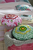 Close-up of fabric cushions decorated with crochet rosette in bucket