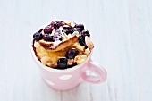 A brioche bake with berries and almonds baked in a cup