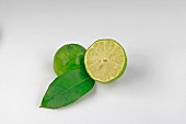 Halved lime with leaf on white background
