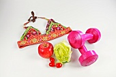 Multi coloured embroidered bikini top, fruits and pink dumbbells on white background