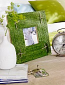 Moss-green, woven raffia picture frame decorated with parcel string