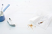 Lemon squeezer, fishhooks and crumbs on white background