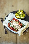 Steamed turkey fillet on a bed of tomatoes and courgette in parchment paper
