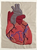 Close-up of human heart sewn on fabric