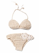 Close-up of beige crochet bikini with floral lace on white background