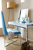 Mirror table with blue chair on wooden floor