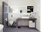Wachtisch mit Mosaikfliesen und Toilette im Badezimmer