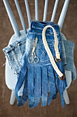 Close-up of denim skirt made of jeans pocket with belt and scissor on chair
