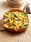 Baked pasta with spinach and chanterelles in baking pan