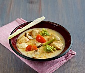 Thai curry soup with chicken in bowl