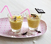 Mango and coconut soup in glass on tray