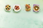 Four varieties of vegetable dishes on green background
