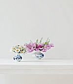 Two posies of daisies and sweet peas on white table