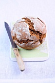 Sourdough rye bread with knife on cutting board, low GI diet food