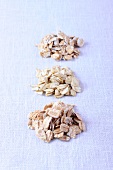 Different types of toasted oatmeal on white background