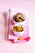 Curry-honey almonds and spiced pecans in small bowls on folded napkin, low GI diet food
