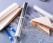 Close-up of foil paper, white paper, plastic bags and sandwich