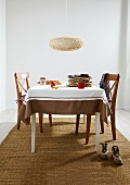 Dining table with chairs, brown carpet and hanging lamp