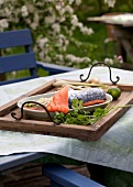 Salmon fillet in tray on wooden board