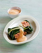 Salmon wrapped in chard with sauce in bowl