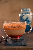 Crème Caramel und Tee in Glastasse