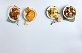Four varieties of meat dishes on white background