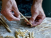 Close-up of dough rolled around stick while preparing fusilli pasta