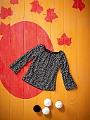 Black and white knitted sweater on patterned background