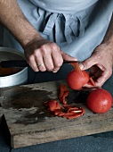 Close-up of tomato being peeled for preparation of tomato sauce, step 2