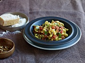 Spiral pasta with saffron, tomatoes and pine nuts in serving dish