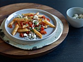 Penne with paprika sugo, mint and feta on plate