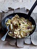 Pasta and cabbage dish in pan with spoon