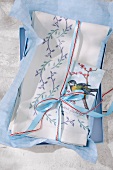 Linen tablecloth with printed leaf tendrils on blue surface