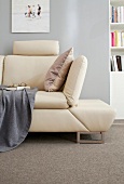 Close-up of beige leather sofa with adjustable armchair